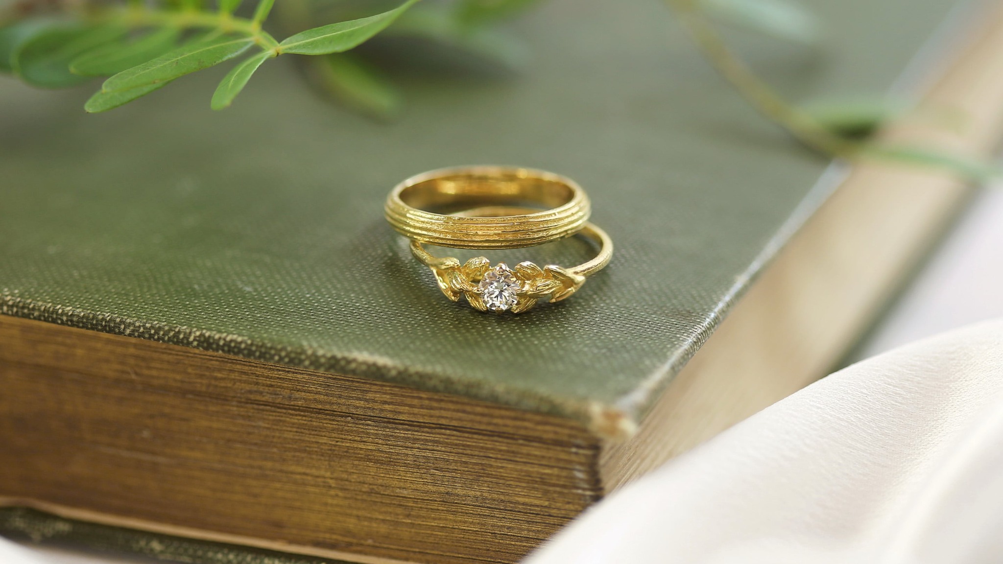 Woman wearing silk neck scarf with silver and gold plated carrot pin and shard leaf creole hoop earrings