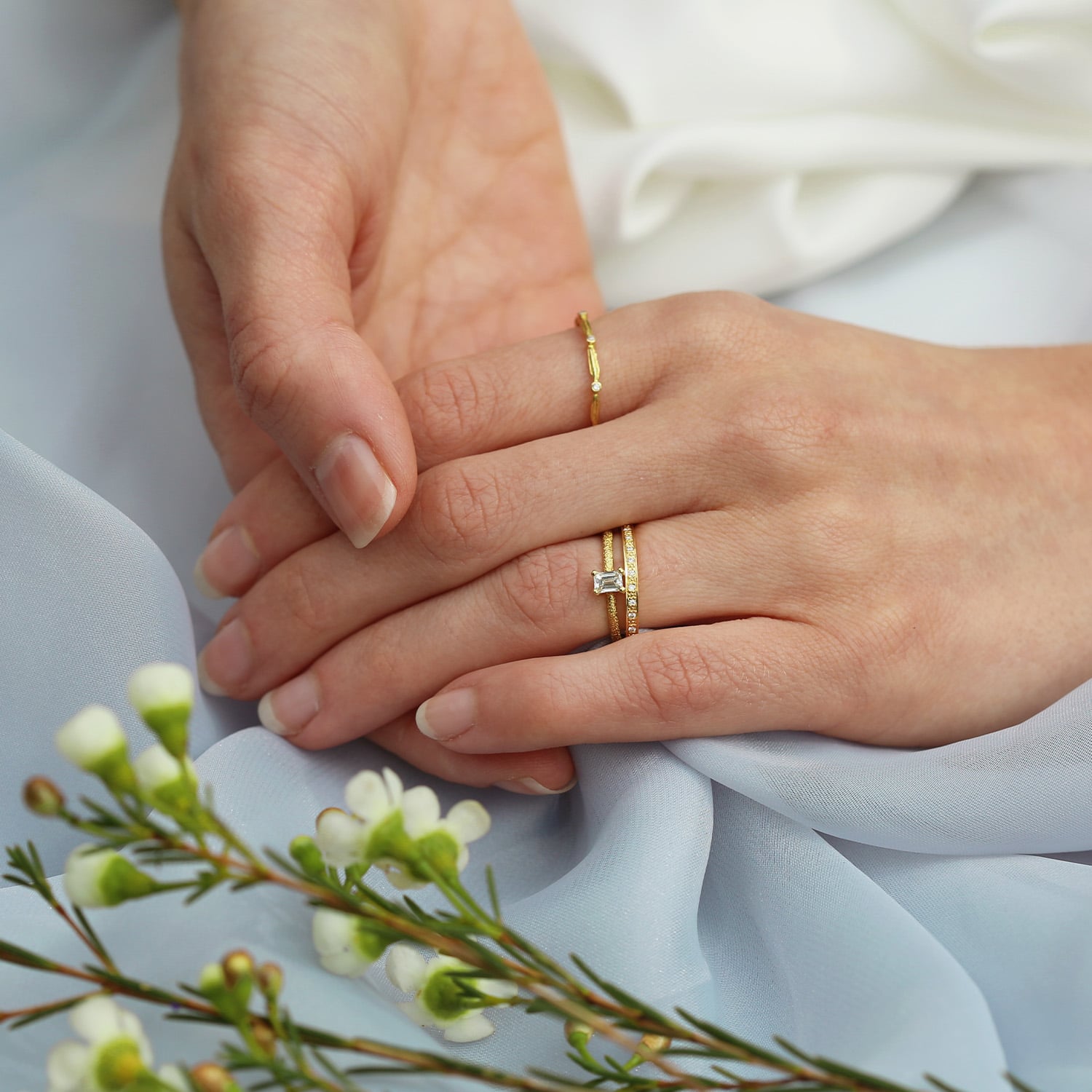 Model wearing Beekeeper Ring with 0.25ct Oval Diamond and Wild Grass Wishbone Ring by Alex Monroe Jewellery
