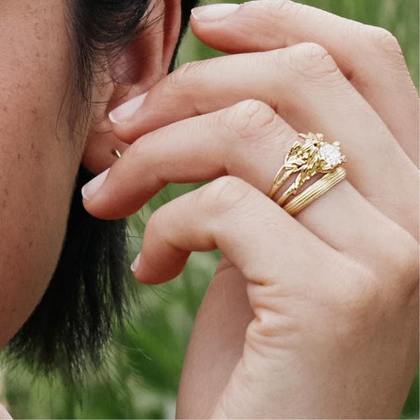 Ring stack including a diamond solitaire ring and textured wedding band.