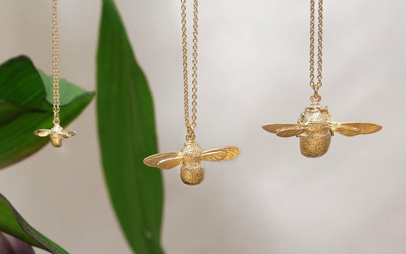 Suffolk landscape of green filds, hedges, trees and blue sky with wispy white clouds. A wooden telephone pole in the foreground.
