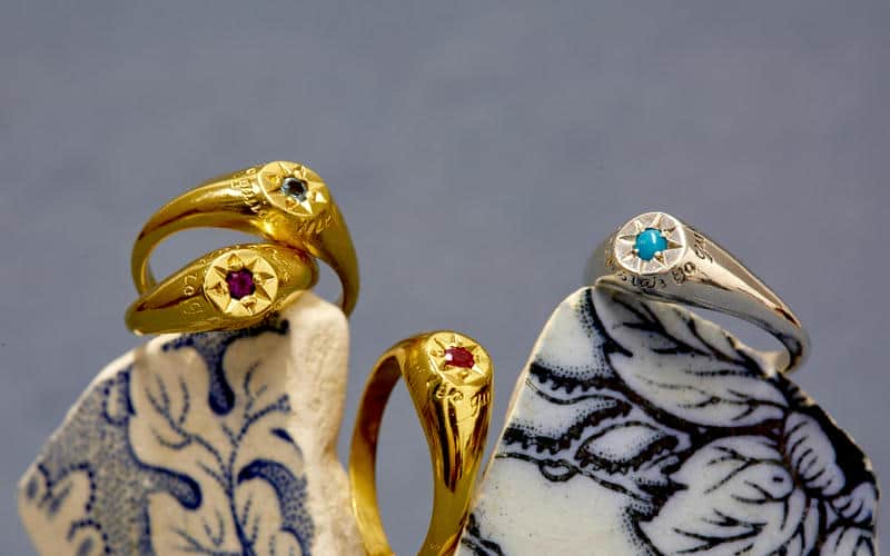 Four signet rings, three gold plated and one silver, with various birthstones set in the center of a star on each.