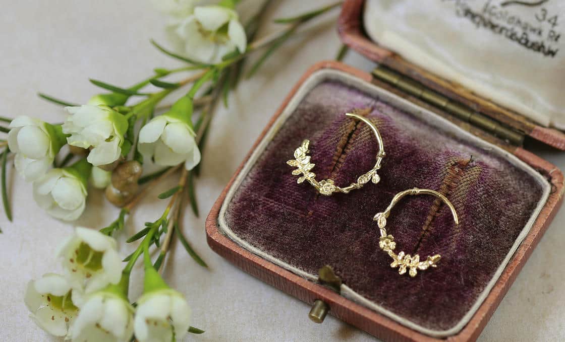 White plastic ring sizer on a green background.