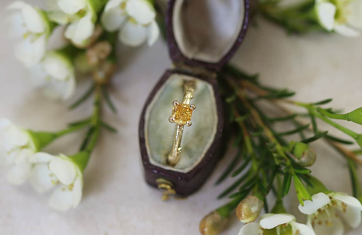 Five red garnet gemstones scattered on a white surface.