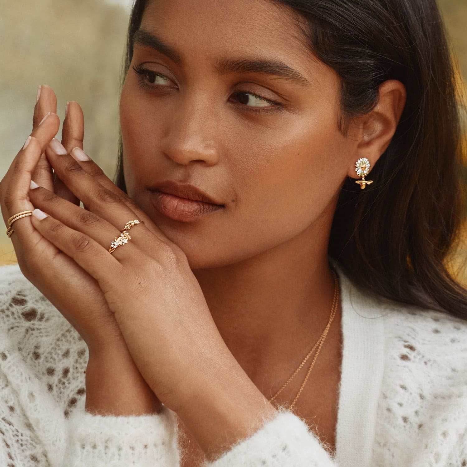  model wearing daisy earrings with drop bee from a Garden Gathering by Alex Monroe Jewellery