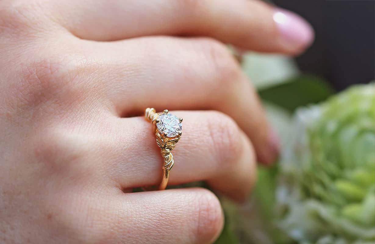 Large white solitaire diamond ring worn on the 4th finger.