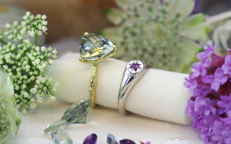 Large green trillion ameythst solid gold ring and silver purple amethyst signet ring with purple flowers.