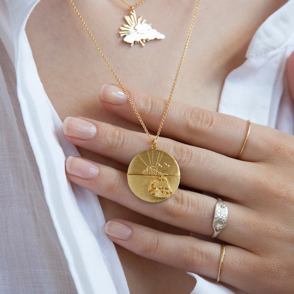 Model wearing alex monroe sail into the sunset folding disc necklace