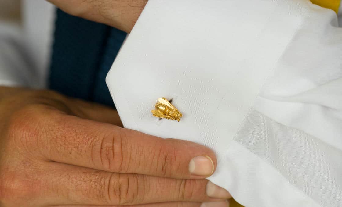 White plastic ring sizer on a green background.