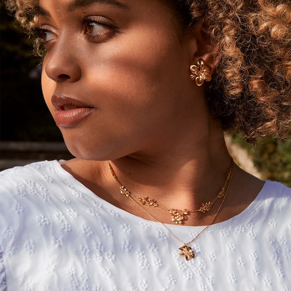 model wearing humble beginnings SS2022 fairmined gold plated rosette necklaces by alex monroe jewellery