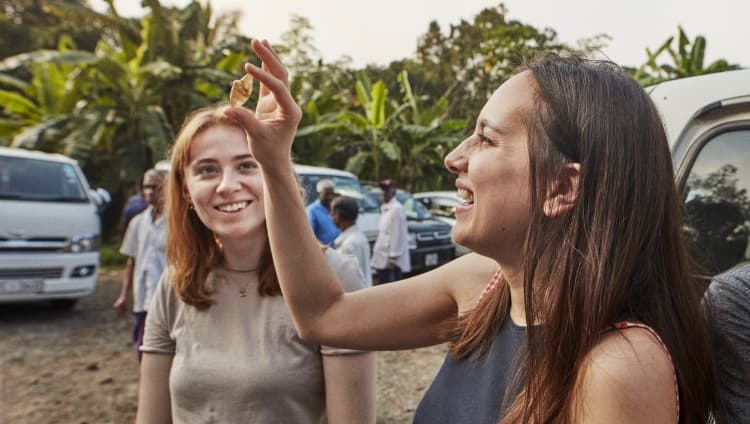 Susie and Amy inspecting rough sapphires at a gemstone street market in Sri Lanka.
