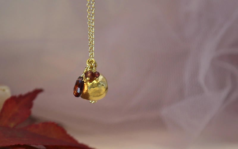 Pommegranate fruit necklace with red garnet gemstone.