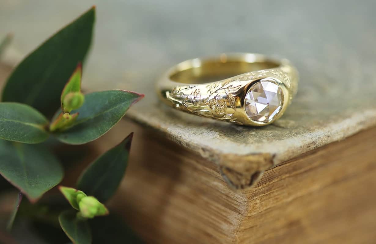 Two yellow citrine gemstones scattered on a white surface.