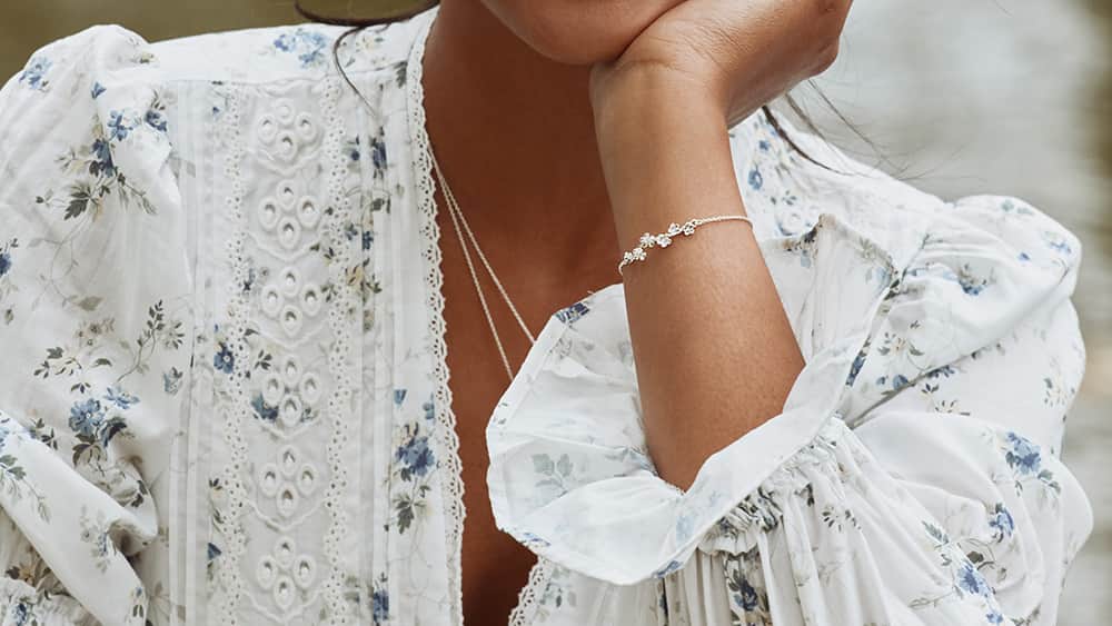 Woman wearing a silver forget me not bracelet.