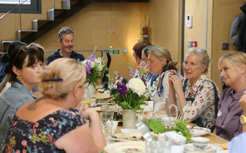 Suffolk landscape of green filds, hedges, trees and blue sky with wispy white clouds. A wooden telephone pole in the foreground.