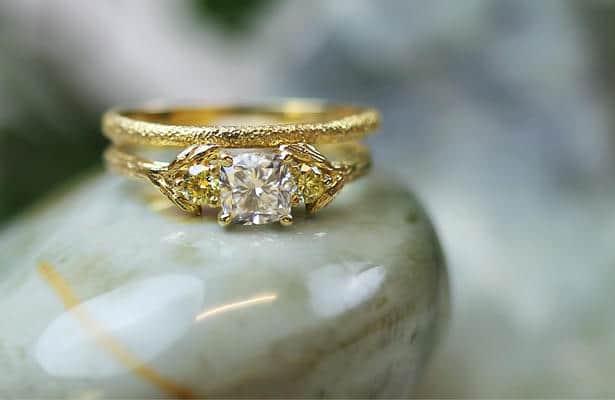 Close up of a harvest seed dimaond solitaire ring and textured wedding band.