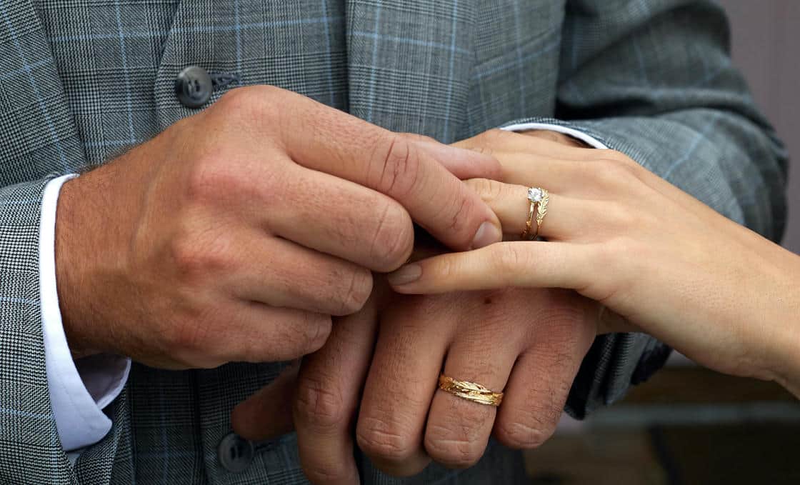 Close up of a harvest seed dimaond solitaire ring and textured wedding band.