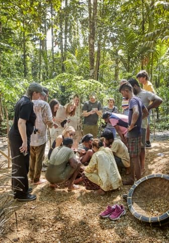 The group gathers round to watch a demonstration of washing gravel to search for sapphires.