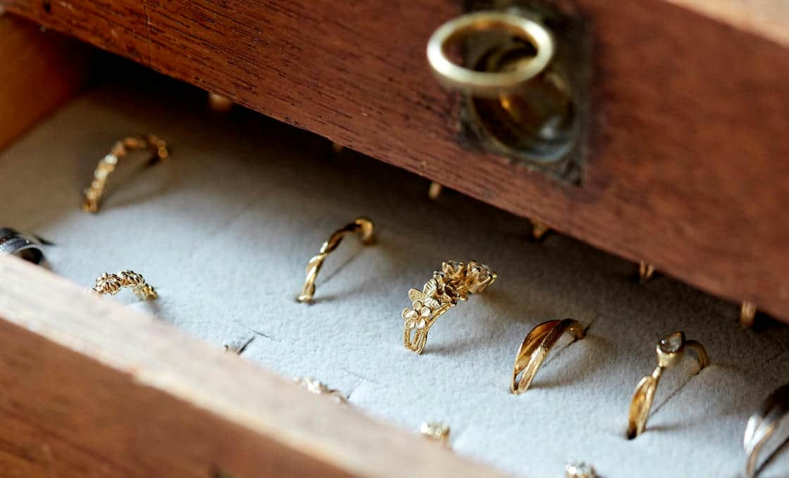 Vintage wooden drawers with a selection of Alex Monroe engagement rings on display.