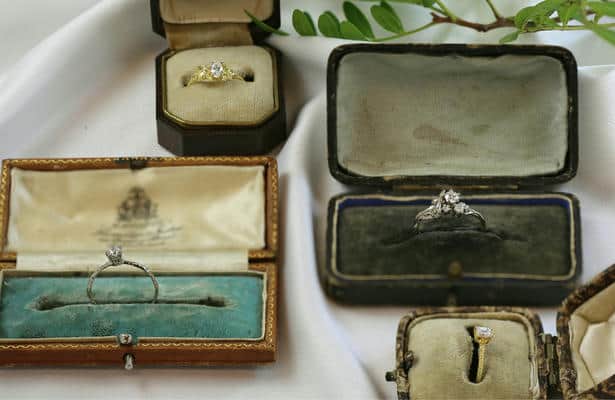 An assortment of vintage ring boxes each displaying an Alex Monroe engagement ring.