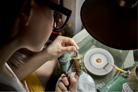 Susie at the Lapidary carefully placing an uncut Sri Lankan Sapphire into the dop for cutting a facet.