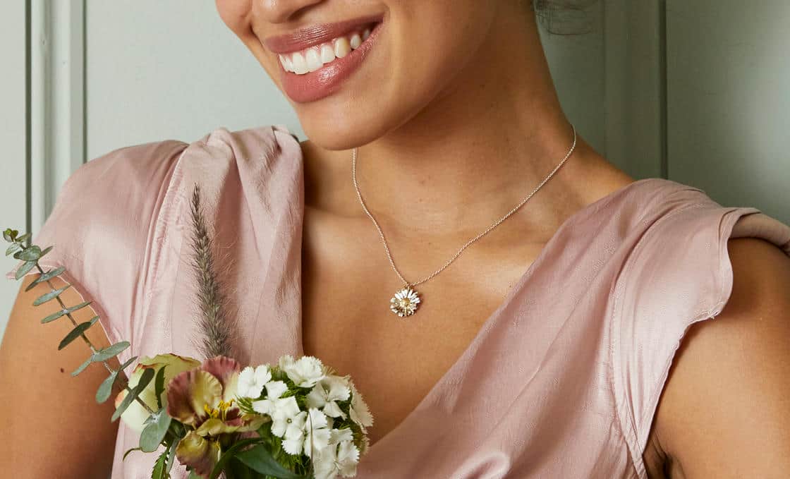 White plastic ring sizer on a green background.